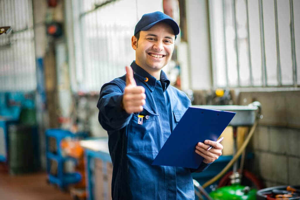 Lächelnder Mechaniker nach bestandener Fahrzeug-MOT-Prüfung