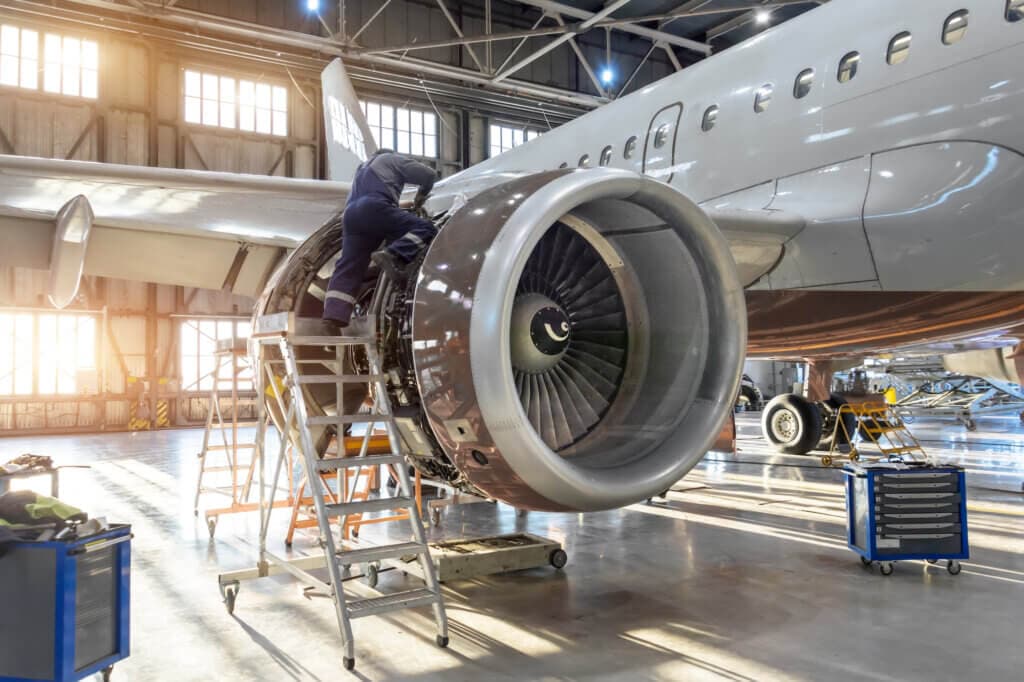 Mecánico especializado reparando el motor de un avión en un hangar